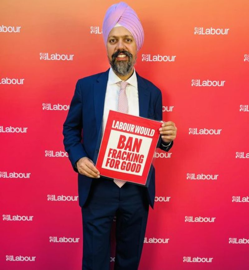 Tan Dhesi with a sign that reads, 